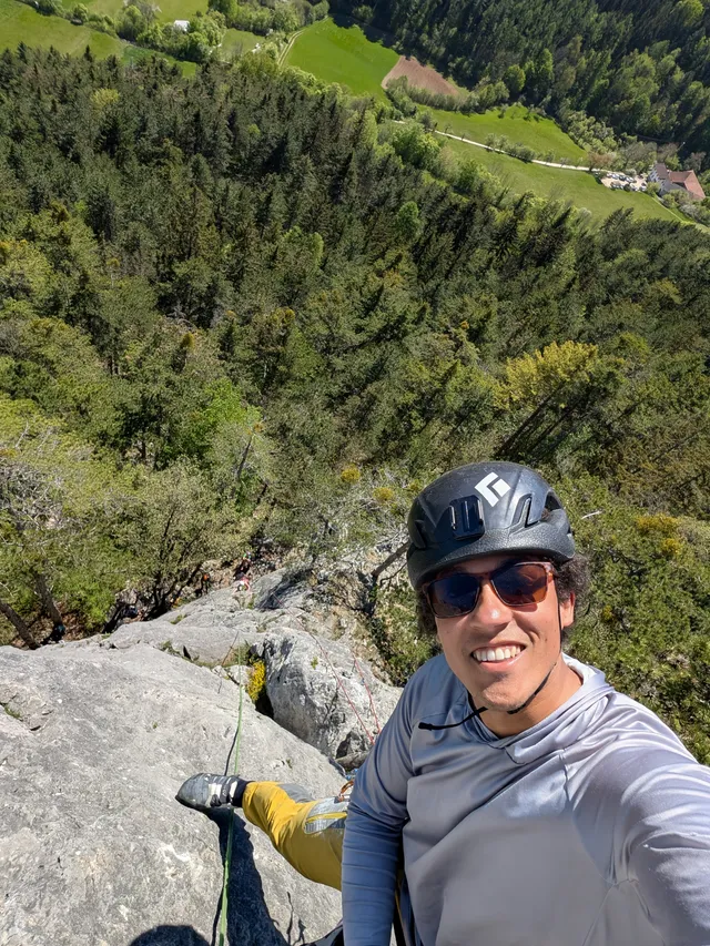 Selfie from the top of a climb, valley far below