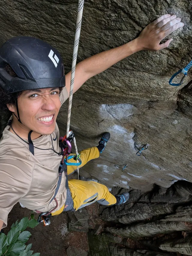 Hanging mid-route on real rock, grinning